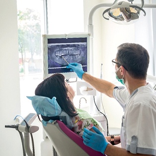 Orthodontist showing patient X-rays of her teeth